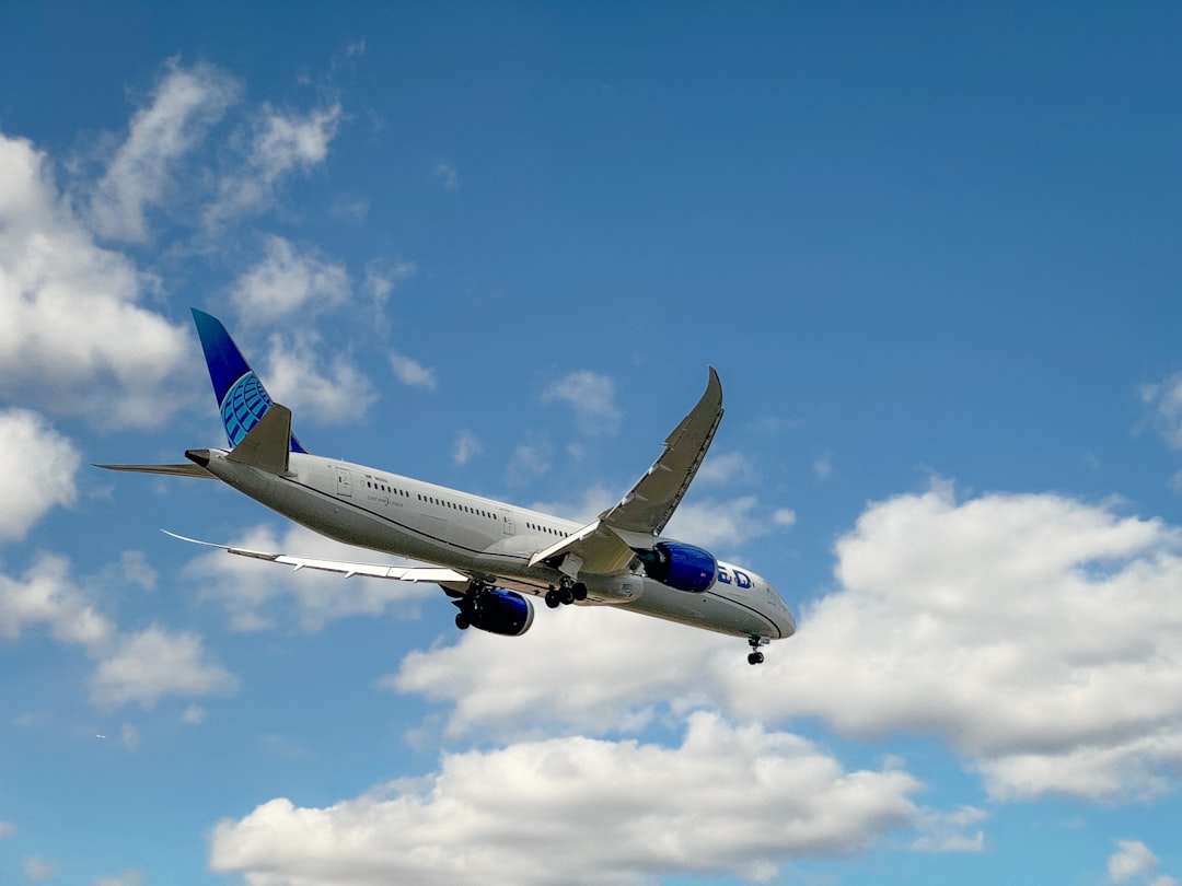 An airplane is flying in a blue sky.